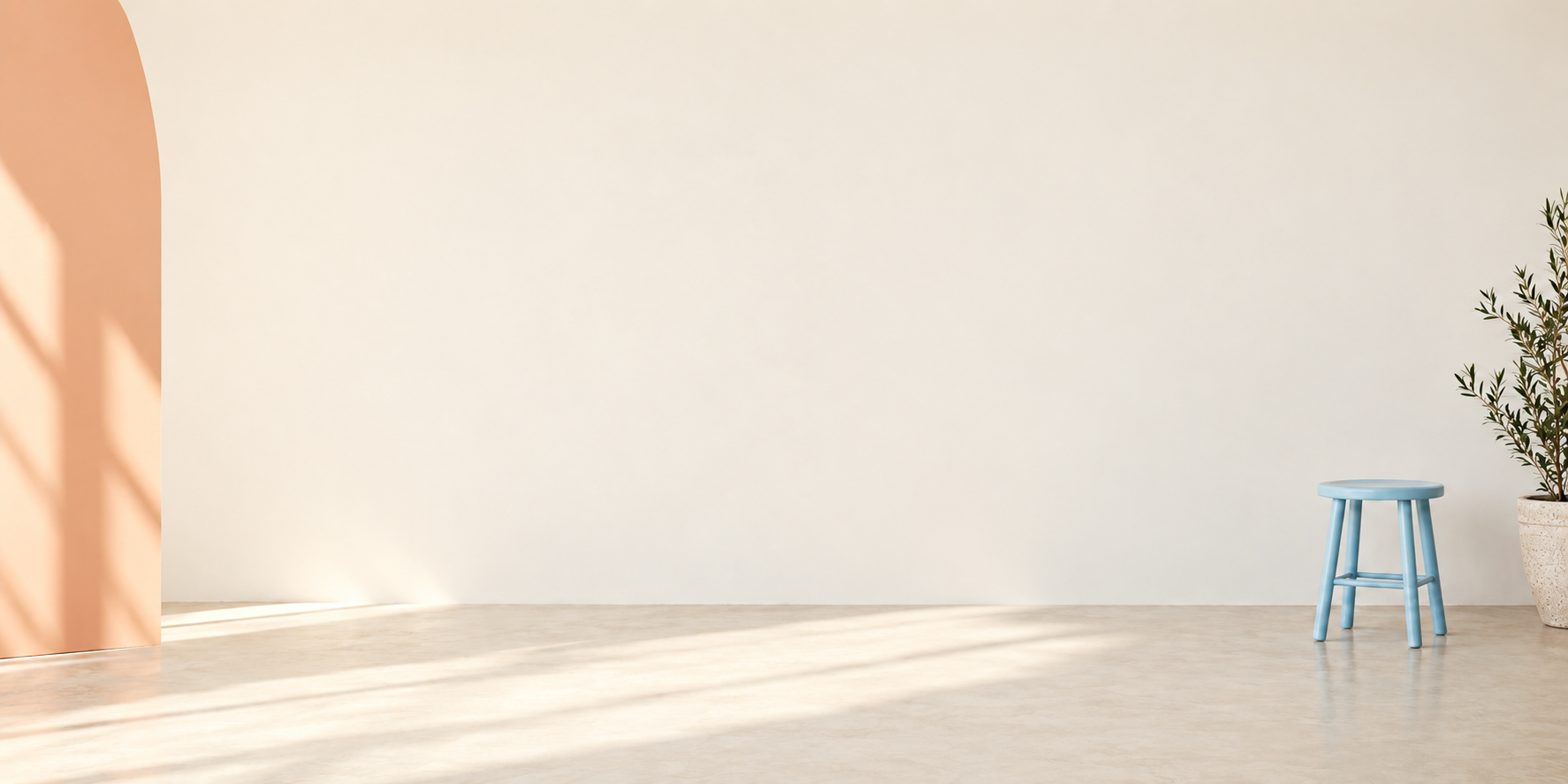 Original reconstructed empty ivory studio with a peach curved wall pale-blue stool and sunlight on the floor